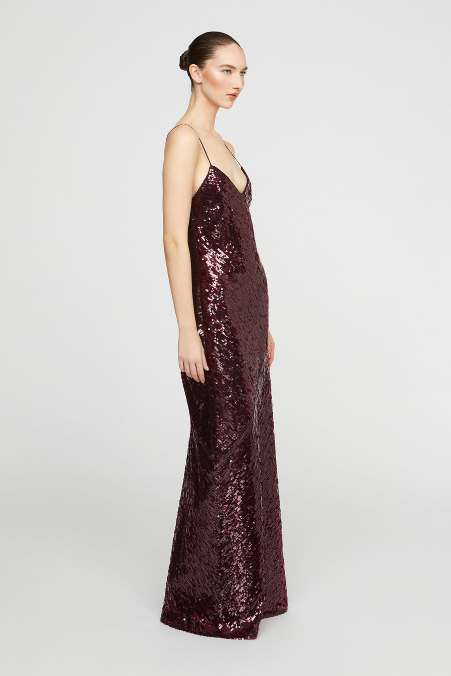 Woman wearing a burgundy sequin dress on a white background