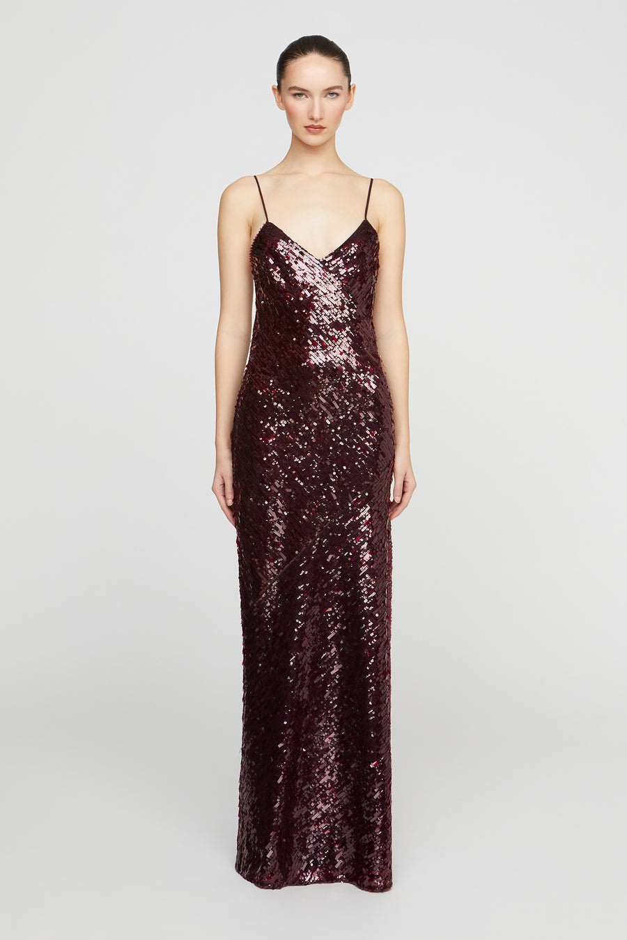 Woman wearing a sparkly burgundy evening gown on a white background