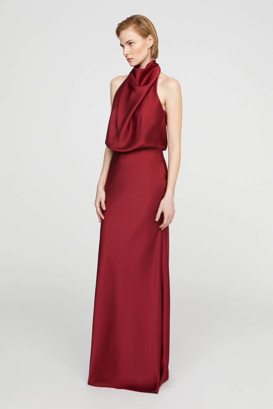 Red evening gown on a model against a white background