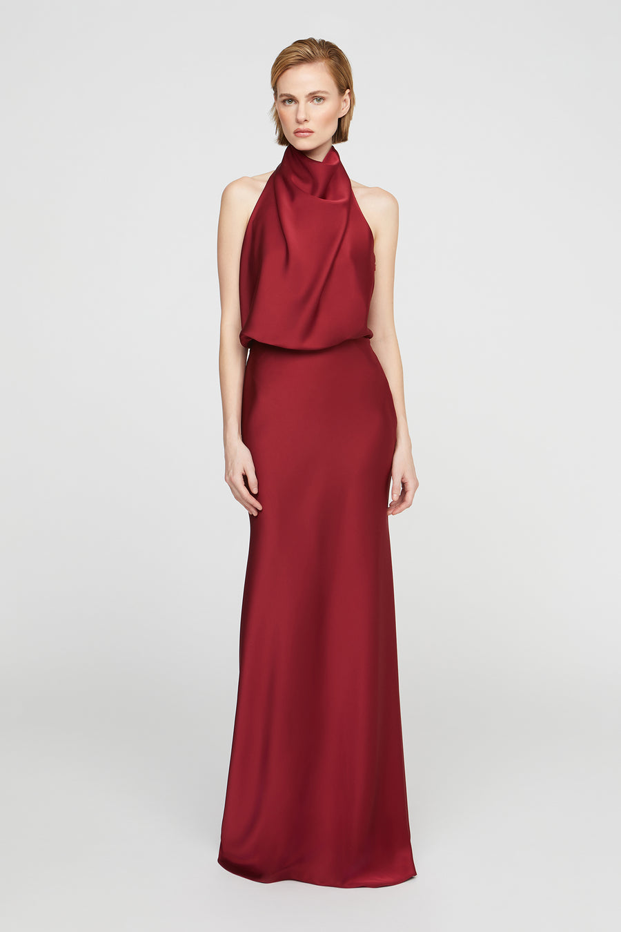 Red evening gown with a halter neck design on a white background