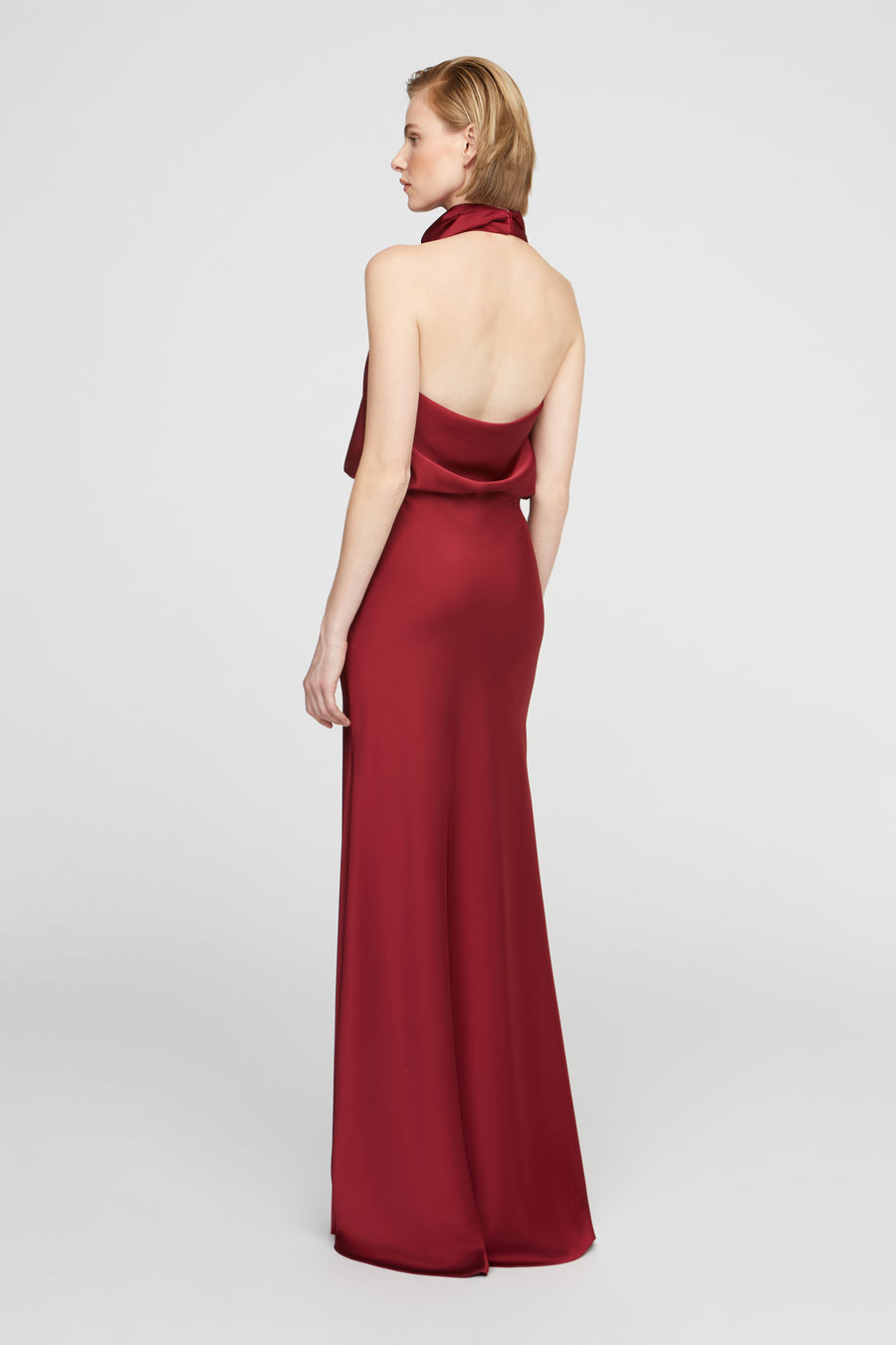 Woman wearing a burgundy evening gown on a white background