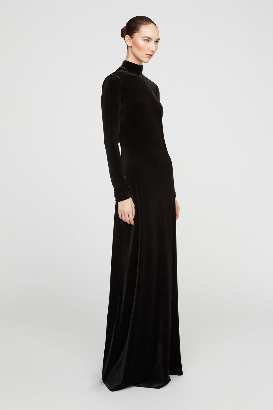 Woman wearing a black long-sleeve gown on a white background