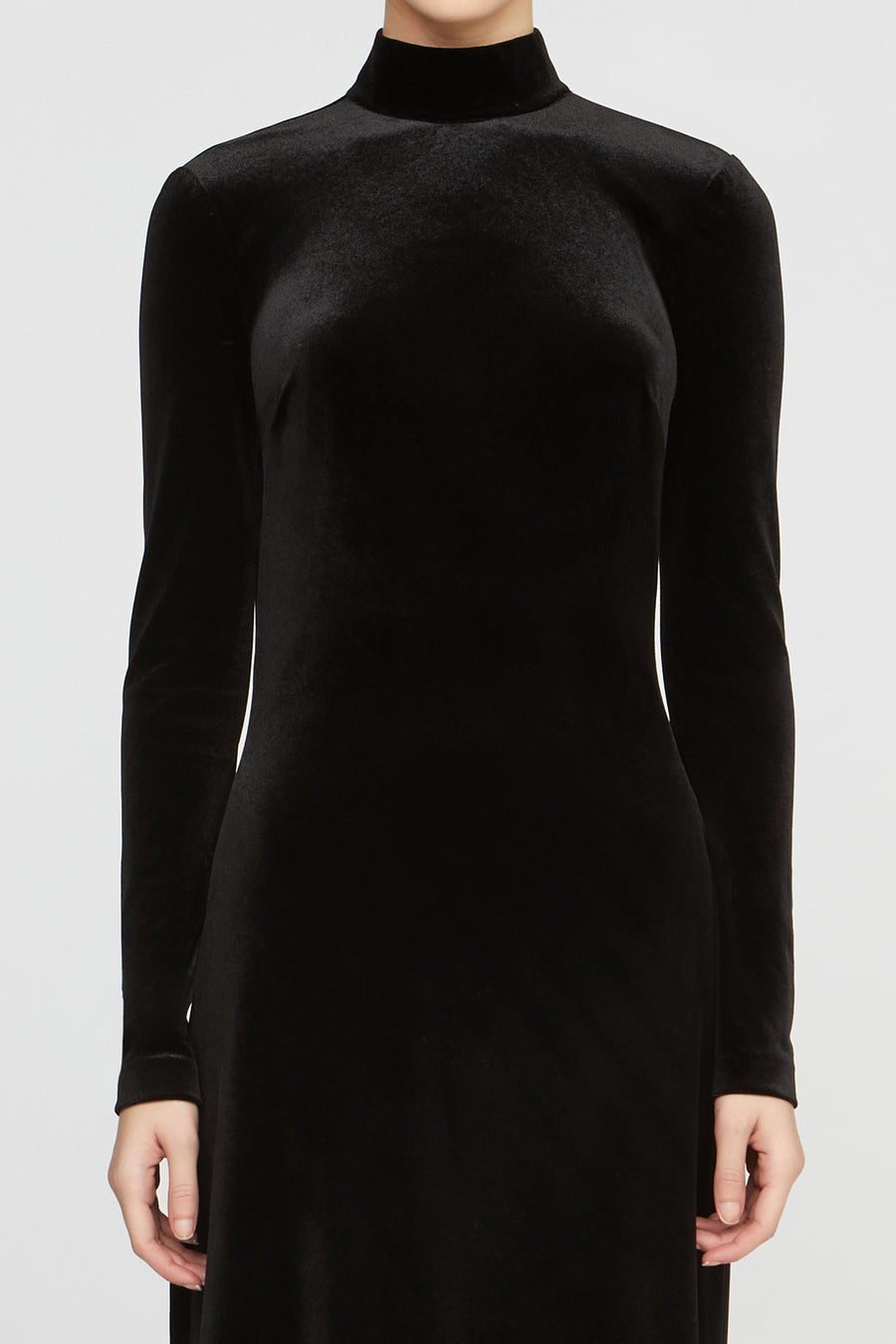 Black long-sleeve dress worn by a person on a light gray background