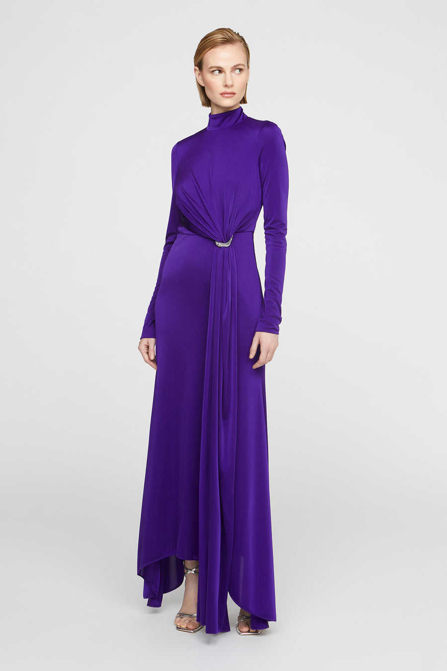 Woman wearing a long purple dress on a white background