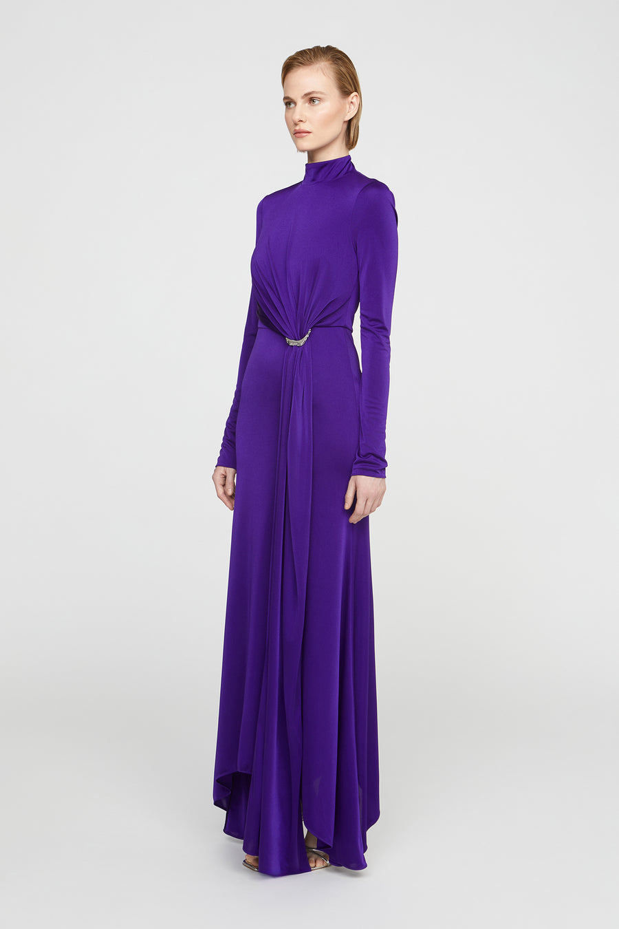 Woman wearing a long purple dress on a white background