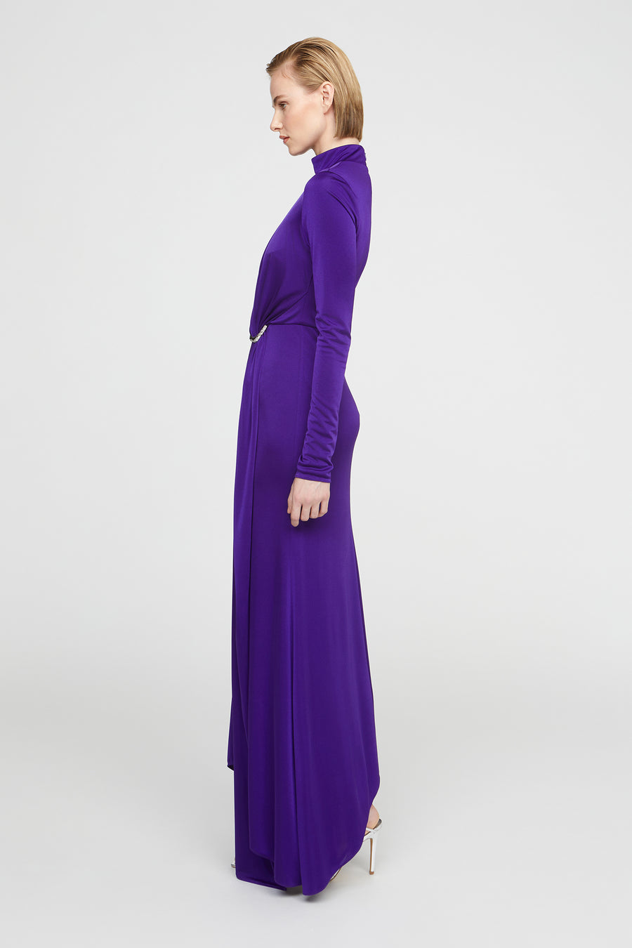 Woman wearing a long purple dress on a white background