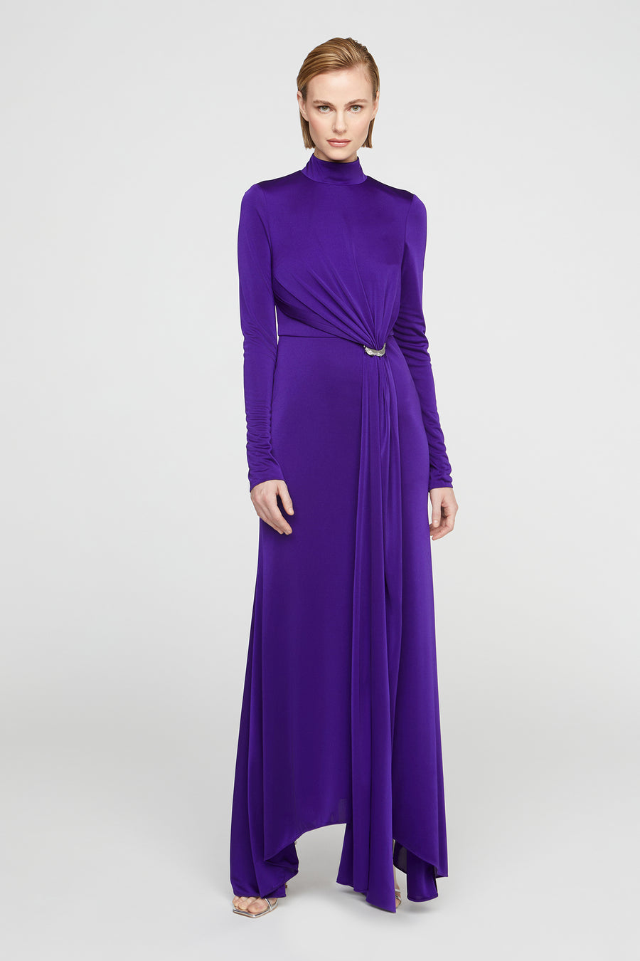 Woman wearing a long purple dress on a white background