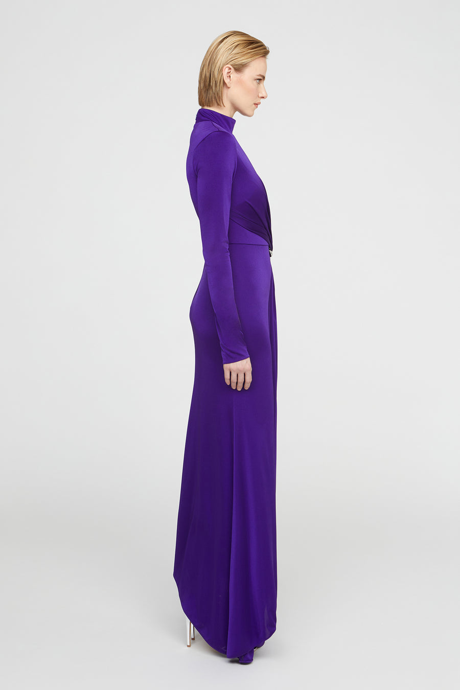 Woman wearing a long purple dress on a white background