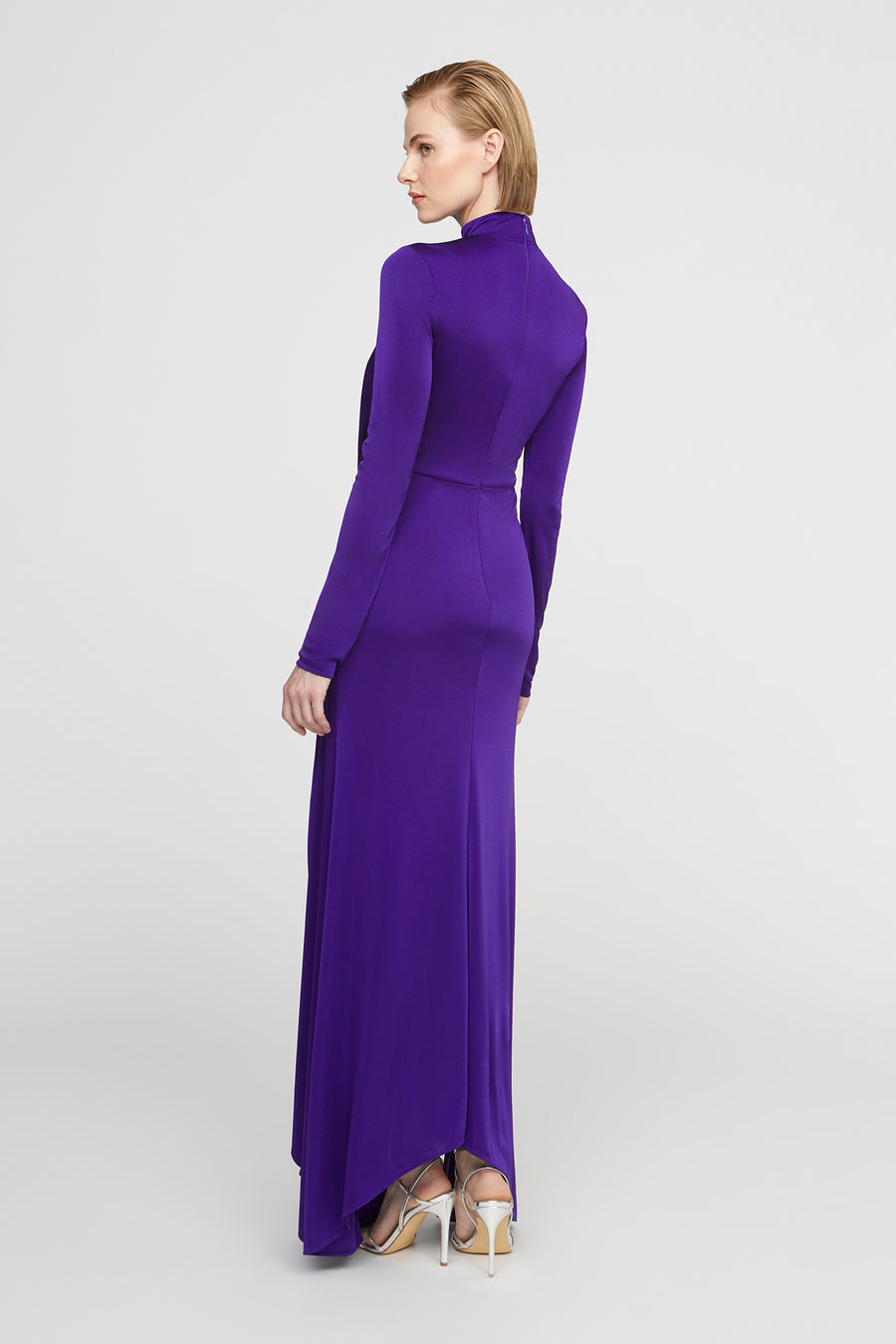 Woman wearing a long purple dress on a white background