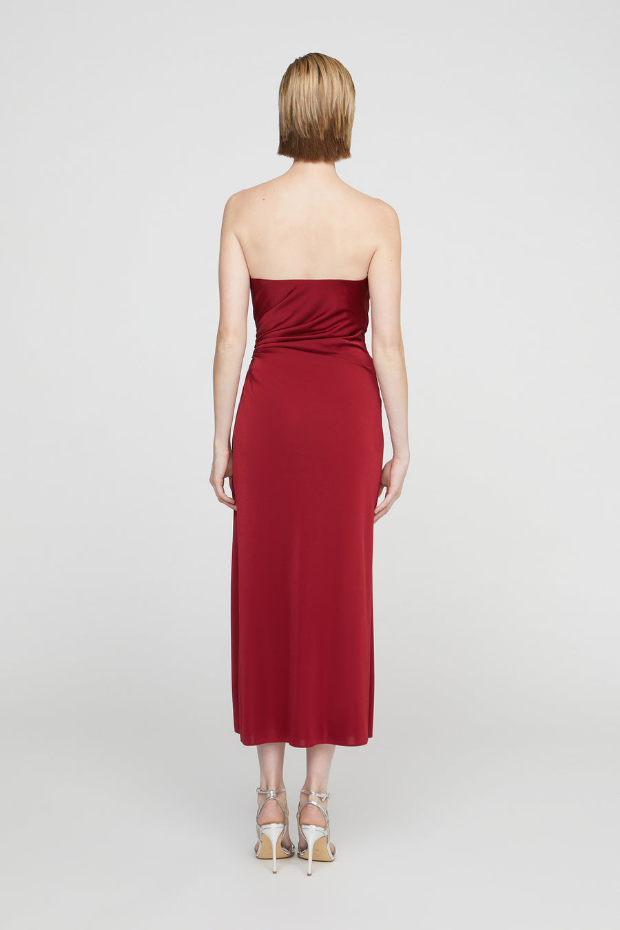 Woman wearing a strapless red dress on a white background