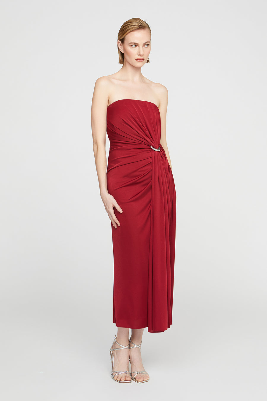 Woman wearing a strapless red dress on a white background