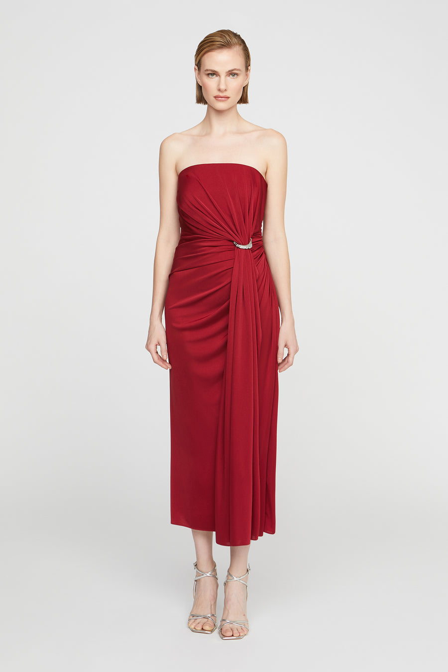 Red strapless dress worn by a model on a white background
