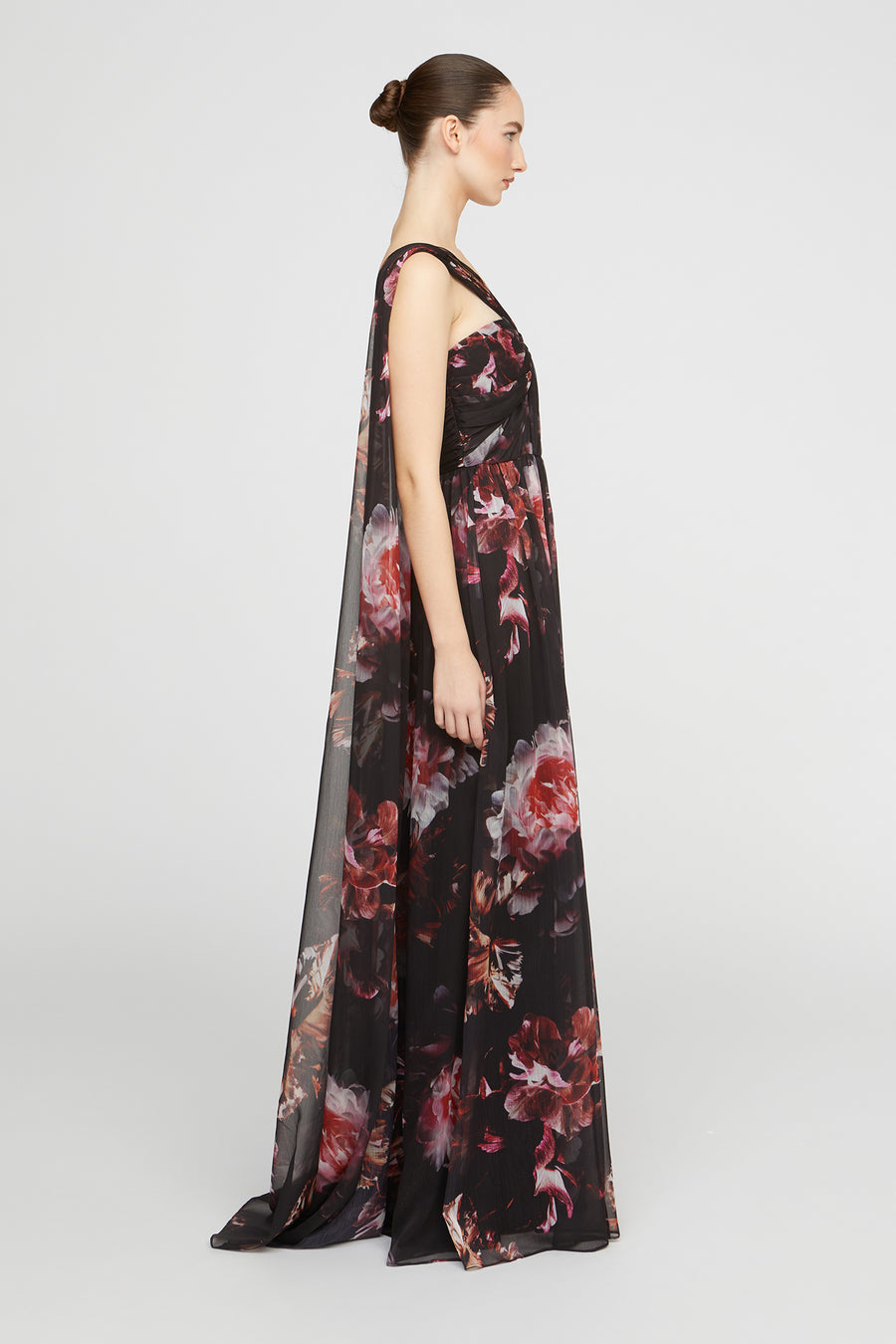 Woman wearing a black floral evening gown on a white background