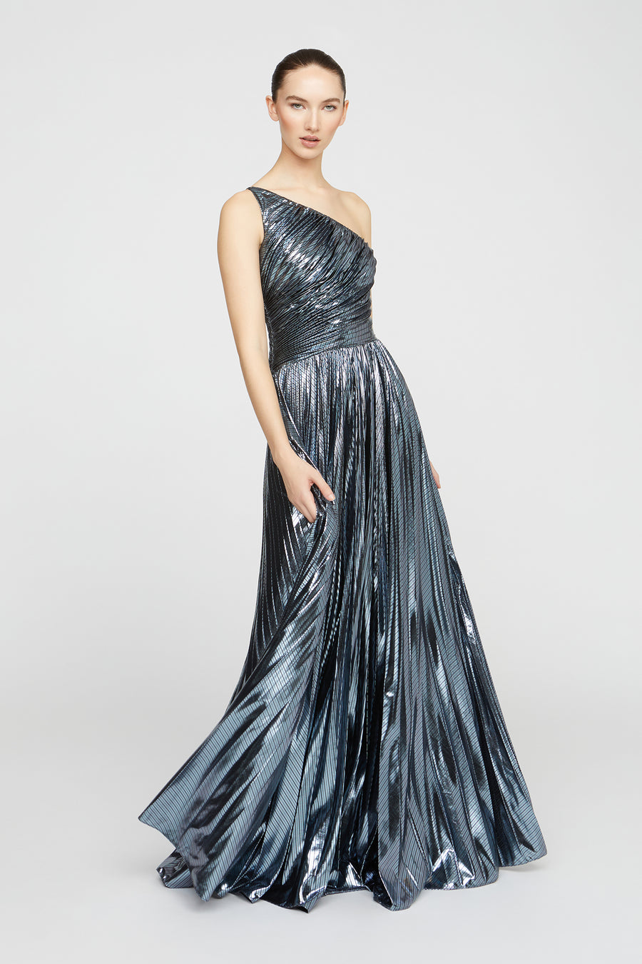 Woman wearing a silver one-shoulder evening gown on a white background