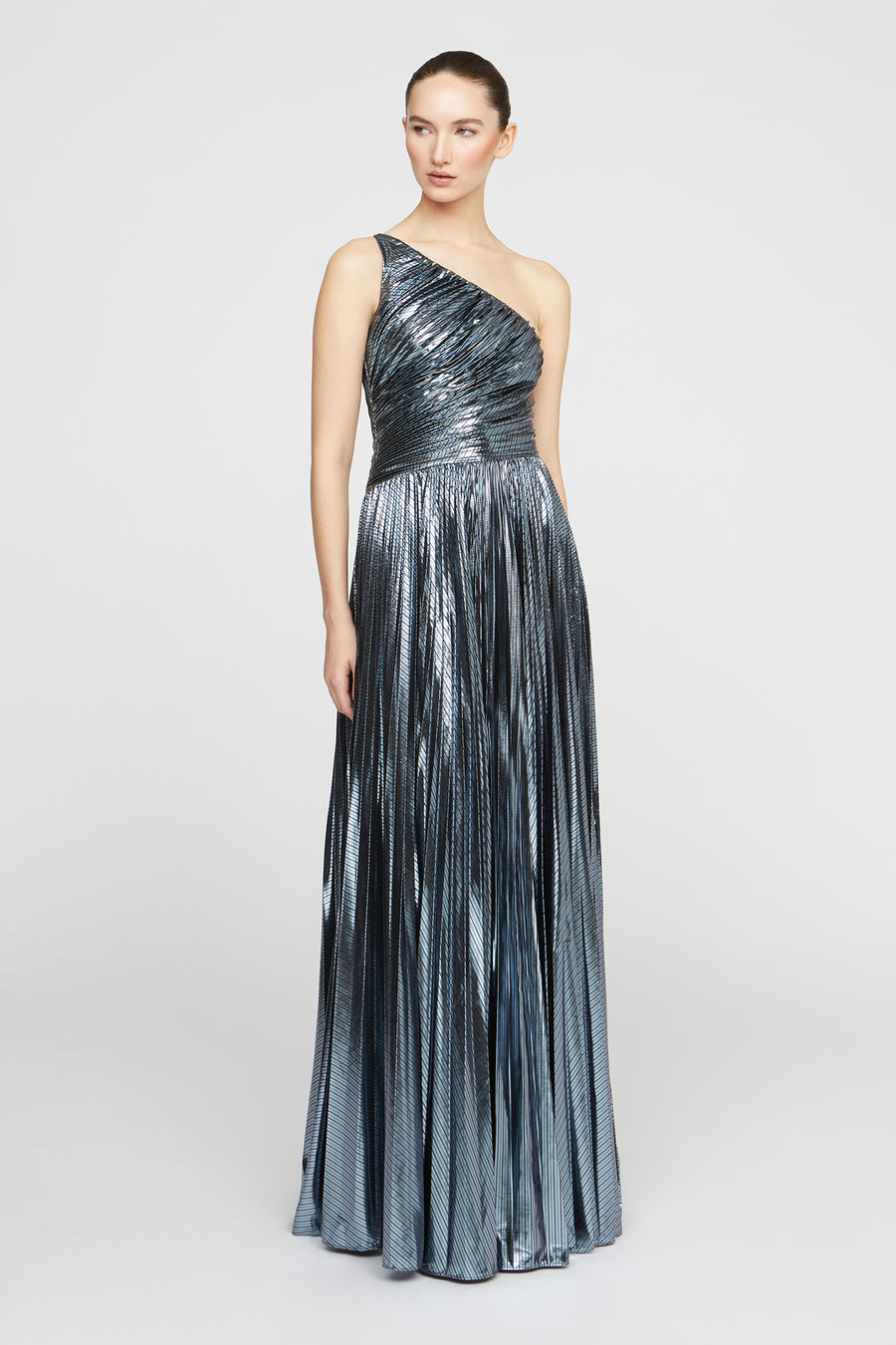 Woman wearing a metallic one-shoulder gown on a white background