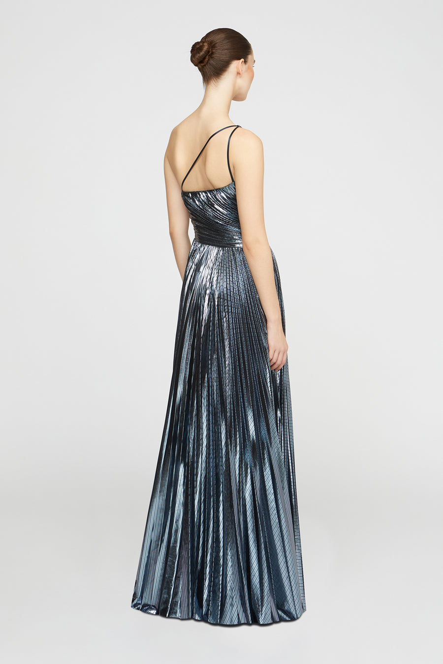 Woman wearing a long, metallic dress on a white background