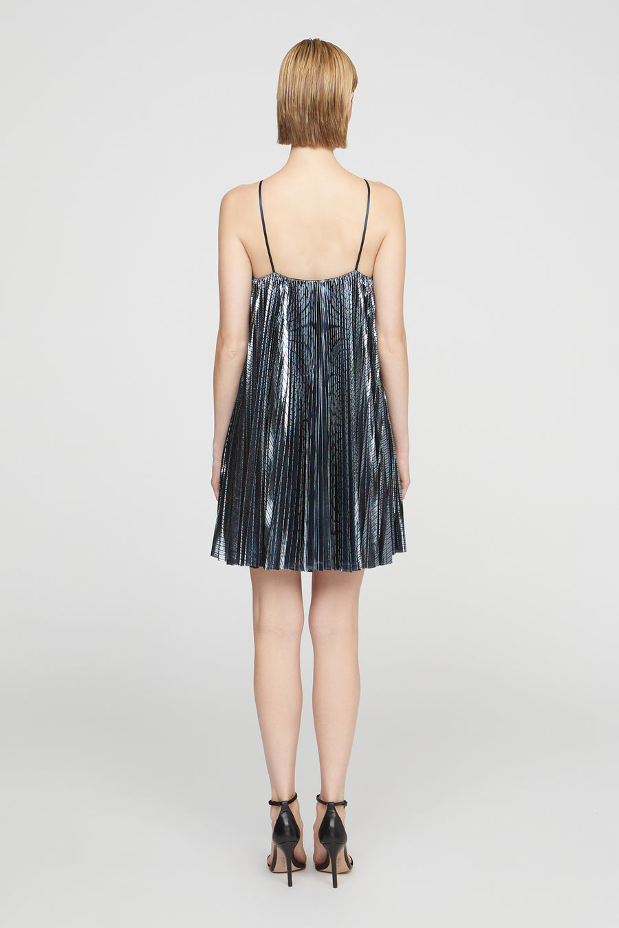 Woman wearing a metallic blue dress on a white background