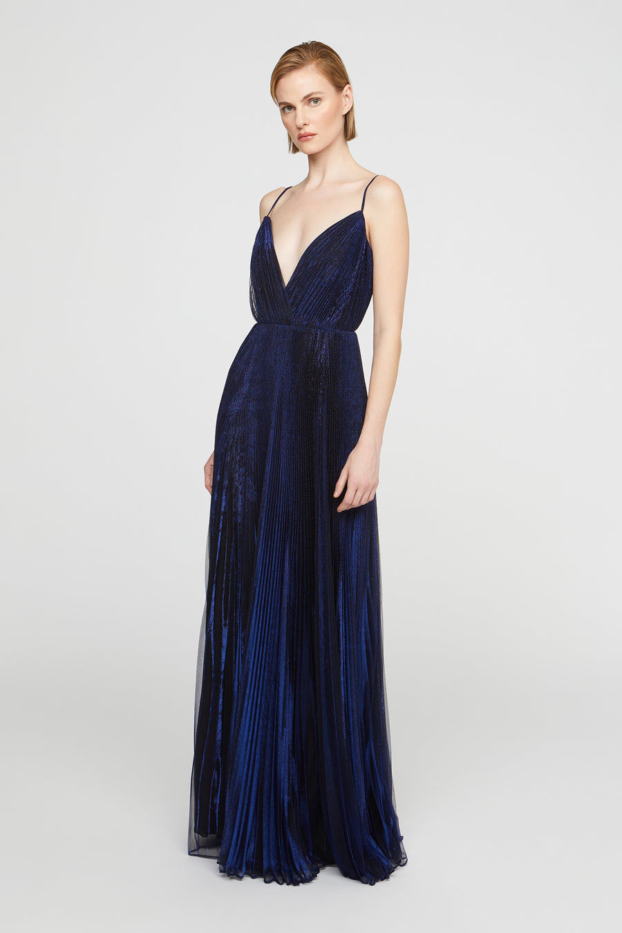 Navy blue pleated evening gown on a white background