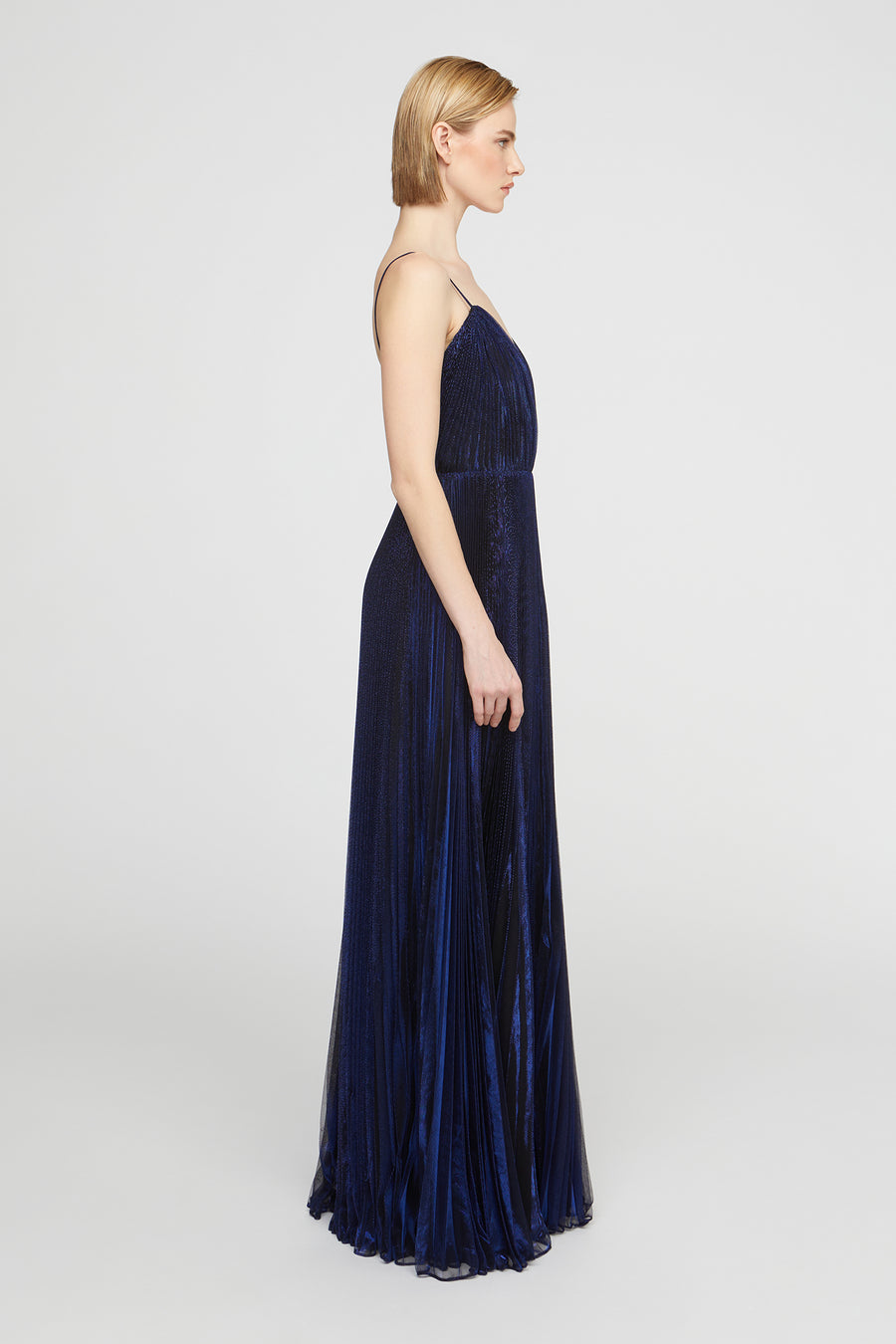 Navy blue evening gown on a model against a white background