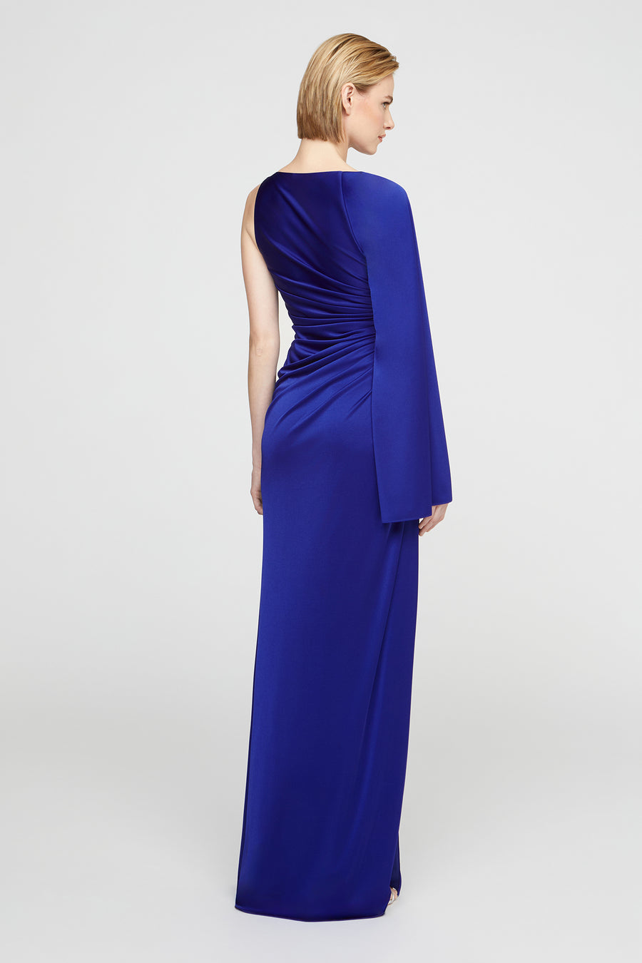 Woman wearing a blue evening gown on a light gray background