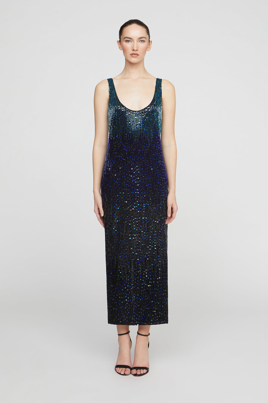 Woman wearing a dark blue sequin dress on a white background