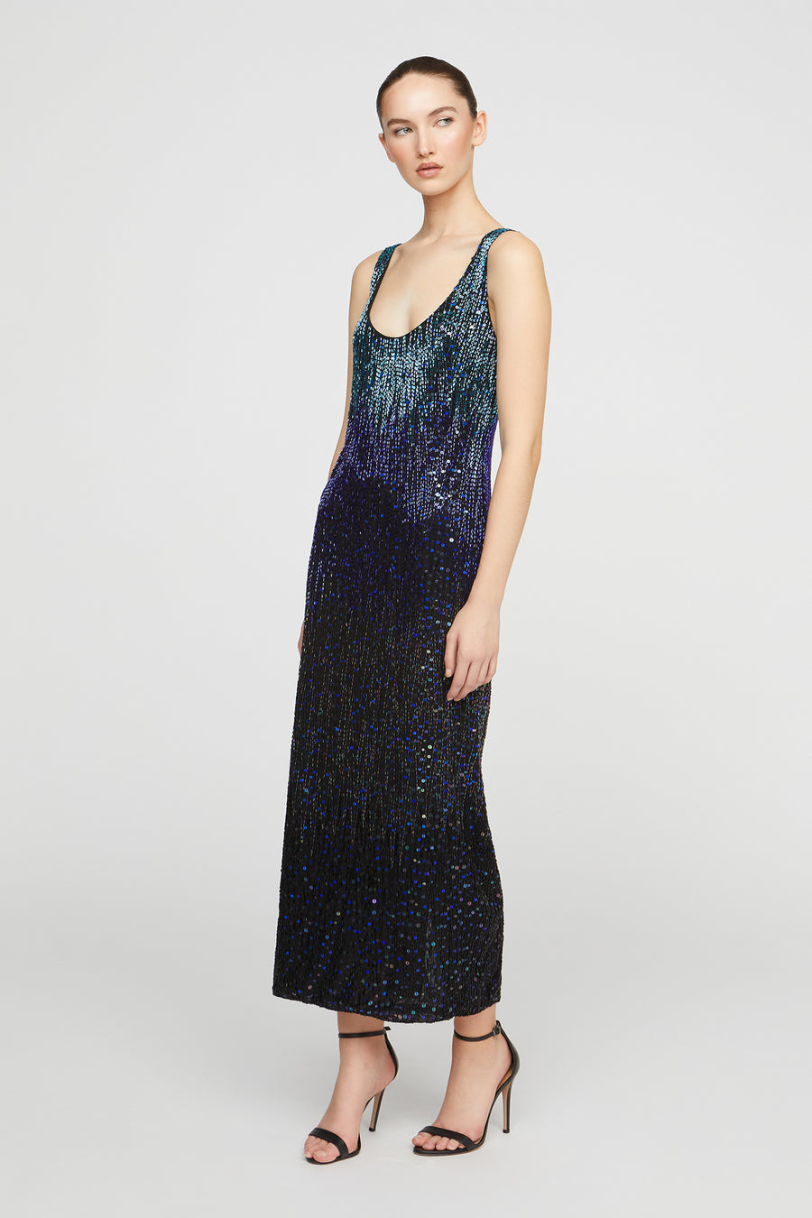 Woman wearing a gradient sequin dress on a white background