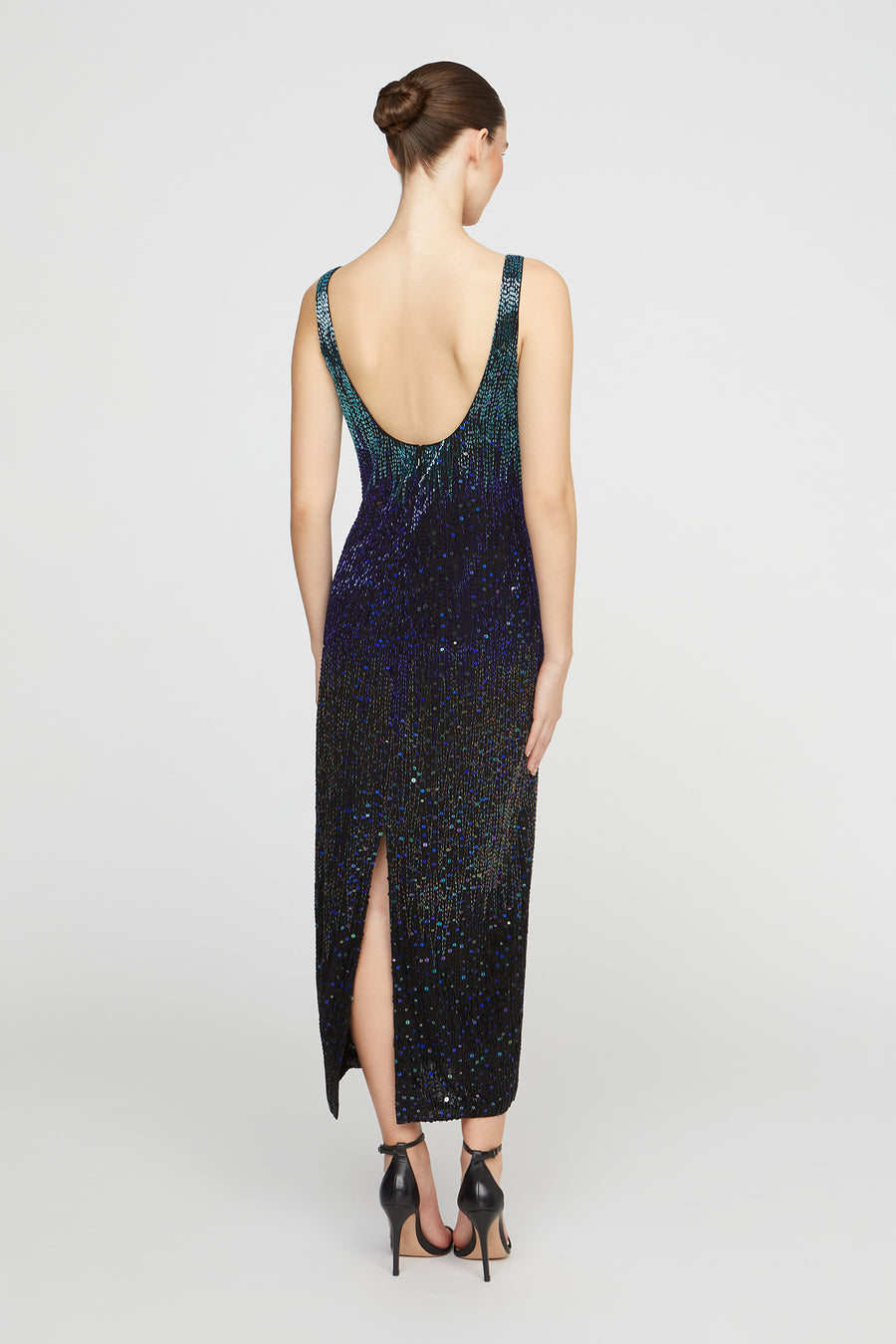 Woman wearing a black and blue sequin dress on a white background